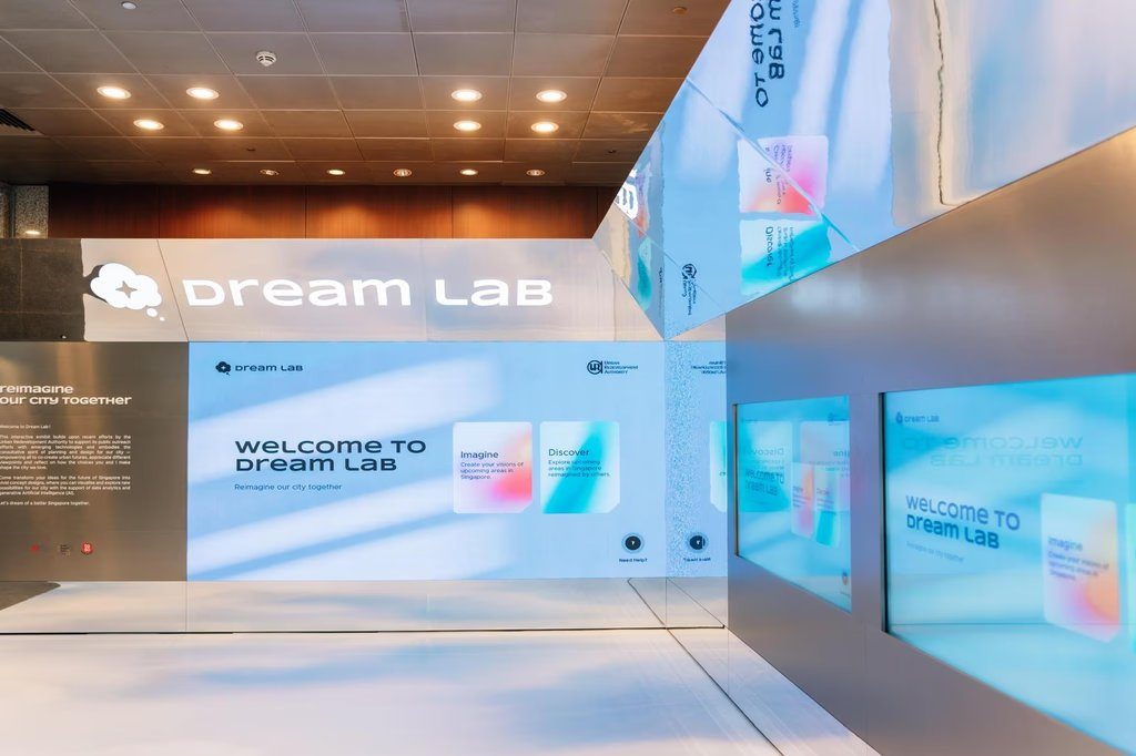Dream Lab exhibition entrance: a mirrored, light-filled space with the welcome wall inviting visitors to reimagine the city together